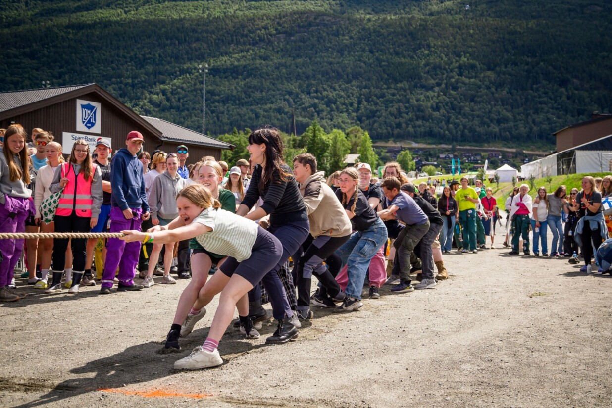 Joukko nuoria vetää köyttä toisten katsoessa ja kannustaessa.