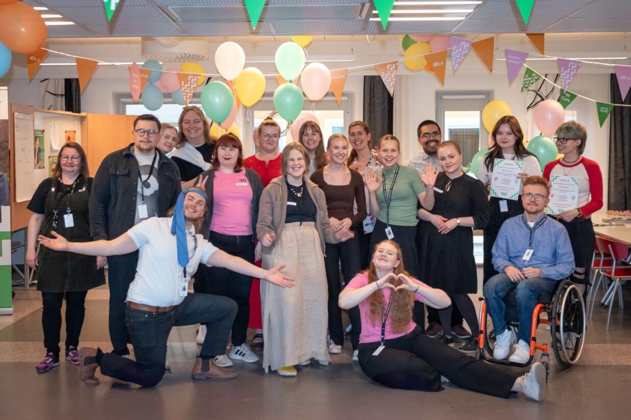 Iloisia 4H:laisia ilmapallojen ja viirikoristeiden keskellä.