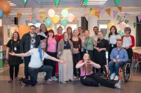 Iloisia 4H:laisia ilmapallojen ja viirikoristeiden keskellä.