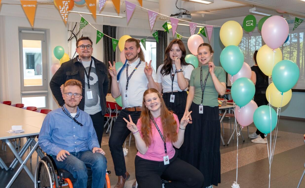 Vaikuttajanuoret iloisina ilmapallojen ja viirien keskellä.