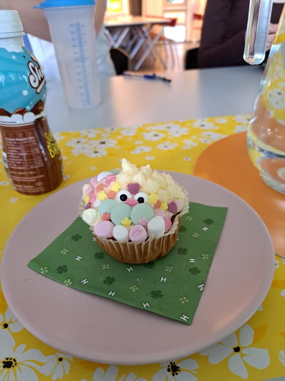 Vaahtokarkeilla, strösseleillä ja karkkisilmillä koristeltu muffinssi.